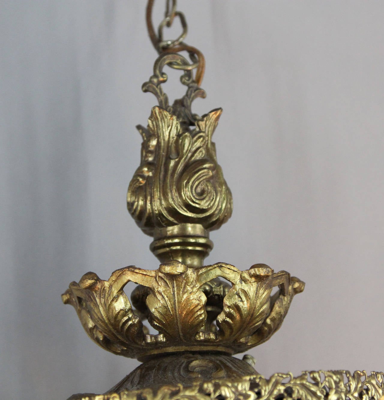 This dynamic pair of pierced, gilt metal; set with iridescent glass 