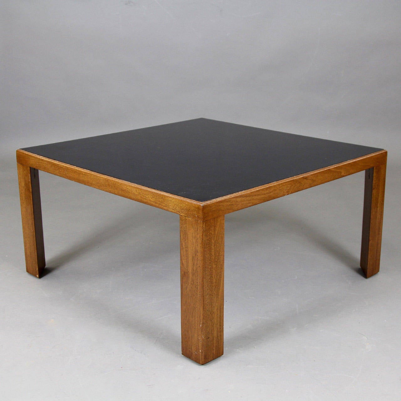 Black glass and wood coffee table in the style of Edward Wormley.