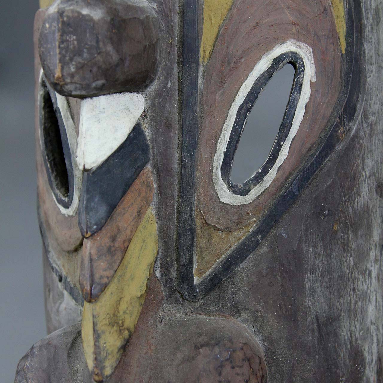Ancestral spirit mask, made of wood colored with natural pigments. Carved and painted mask with elongated nose, further decorated with an antelope head and a second mask/man with arms stretched towards eyes of antelope, decorated with cowrie shell
