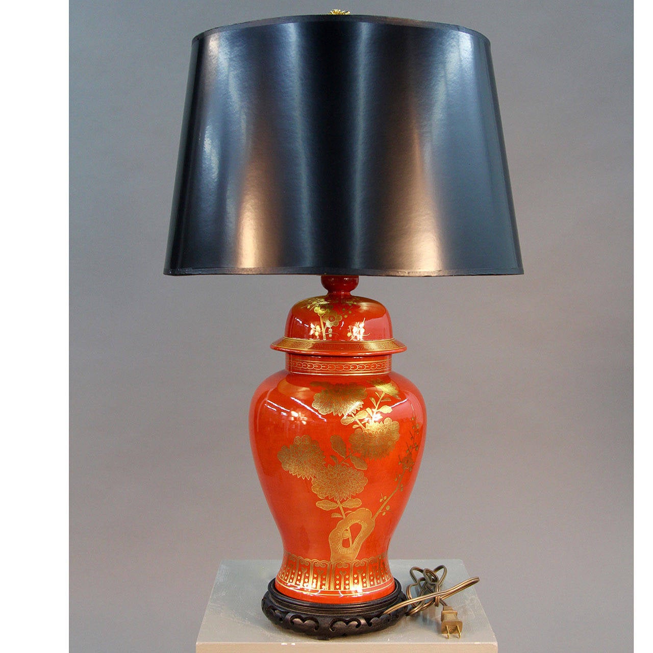 Beautiful vintage porcelain burnt orange ginger jar table lamp with hand-painted gold birds and cherry blossoms. New 17” black drum shade with a gold lining. Rewired.