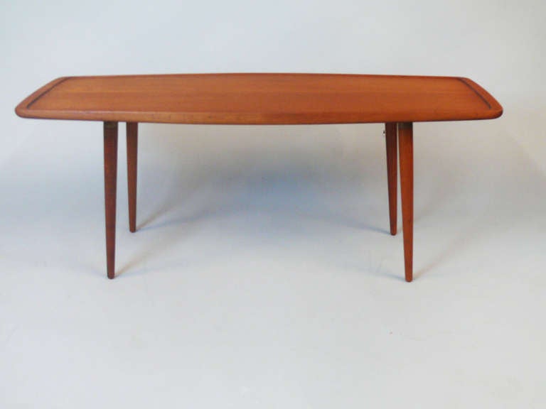 Coffee table designed and manufactured by Cabinetmaker Jacob Kjaer Copenhagen. The top has a slightly raised edge. The solid legs are slightly conical with brass mountings. Original manufacturer’s label on bottom.