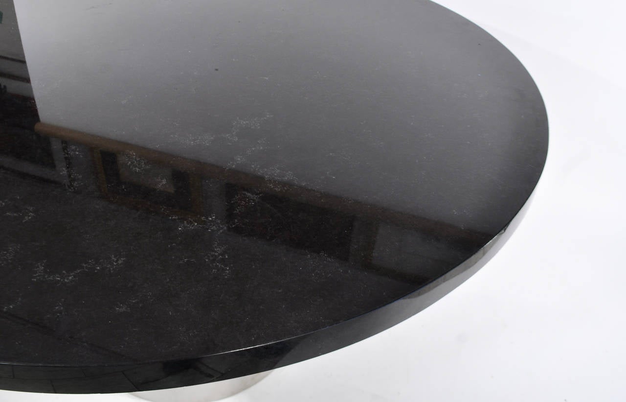 Very thick black speckled marble top on chrome drum base. Round dining or conference table. Good condition, few minor chips to marble edge. 

Extremely heavy top.