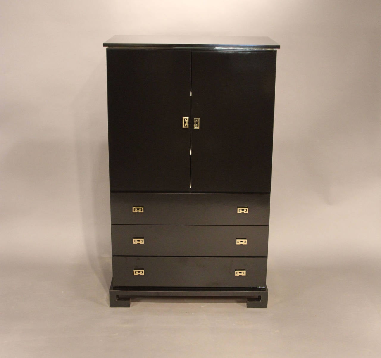 Stunning black lacquered cabinet serves as an armoire, dry bar, storage cabinet for linens or clothing too many uses to mention. Doors open to reveal divided interior sections with adjustable shelving. Cabinet also has three roomy drawers, all