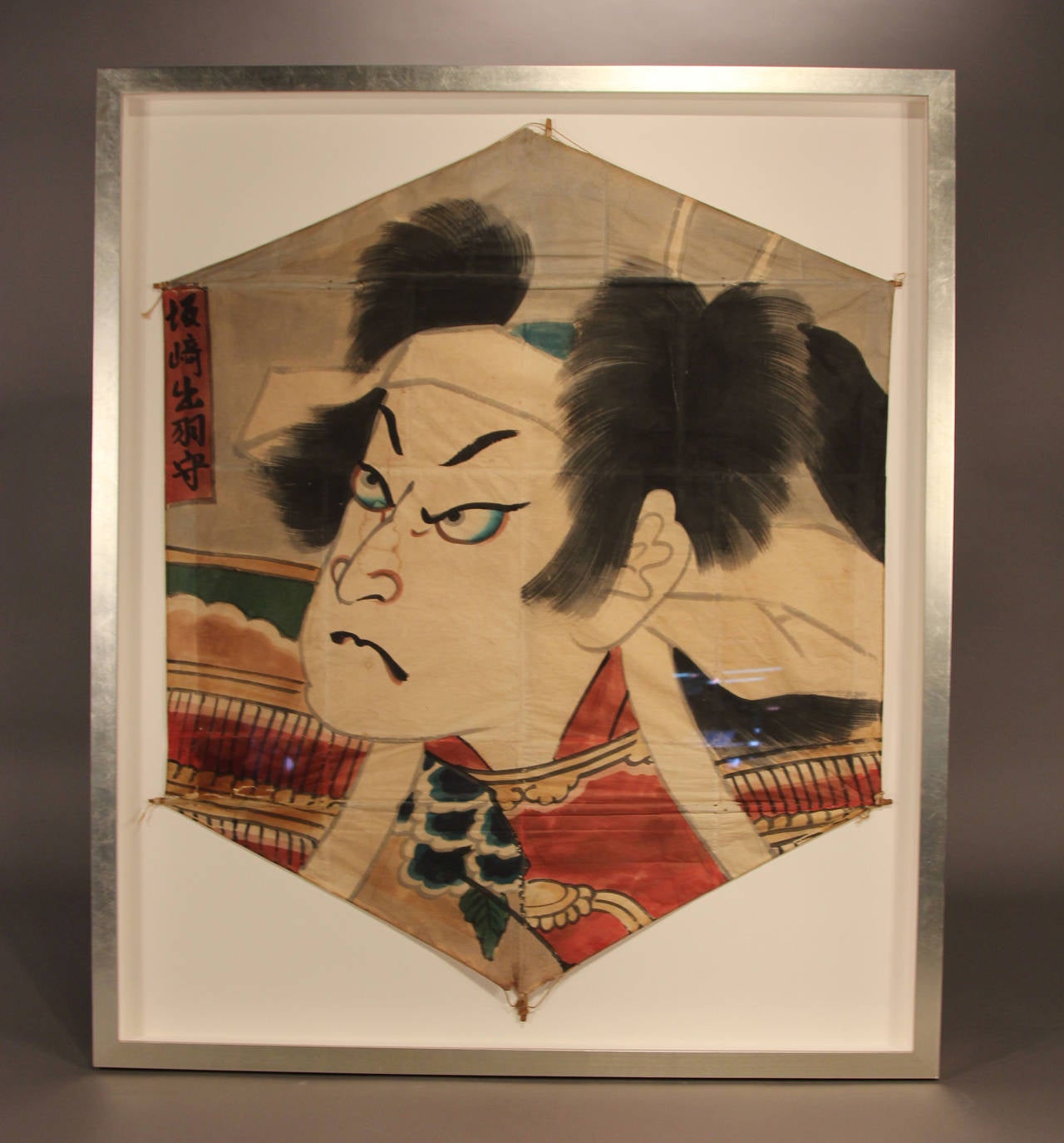 Item description: An incredible hand-painted 19th century Japanese fighting kite, this piece is a large and bold work of art in every way. A traditional “fighting kite” is brush painted with bright colored natural dyes and black ink on washi