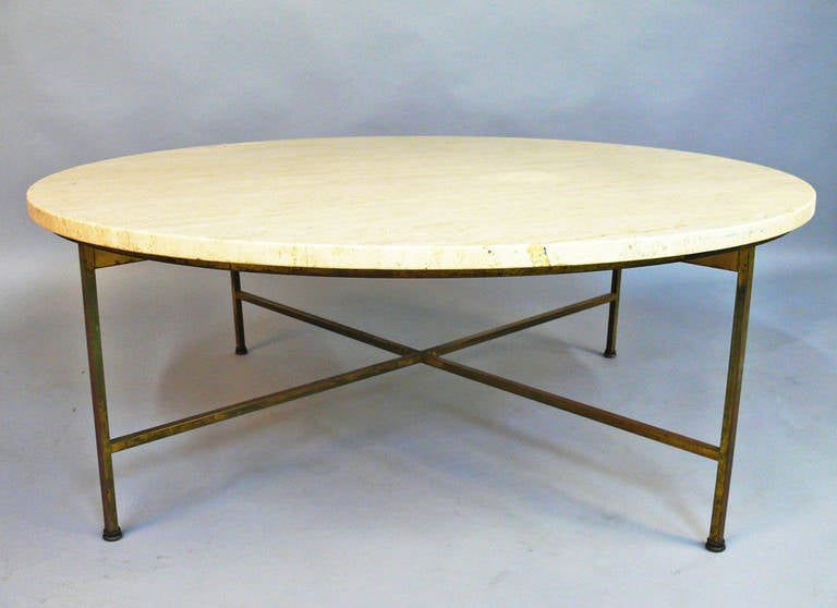 This is a Paul McCobb Travertine top coffee or cocktail table.  Has brass cross base.  Nice vintage piece.  Travertine has some minor wear and brass on the base is tarnished with a vintage patina.