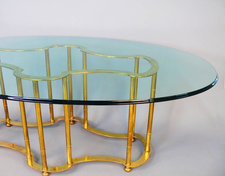 Truly a rare and gorgeous dining room table. This solid brass Racetrack Table by Mastercraft has the original beveled 3/4 Inch oval glass. Set of chairs also available under separate listing. The table and glass are very heavy solid pieces. 