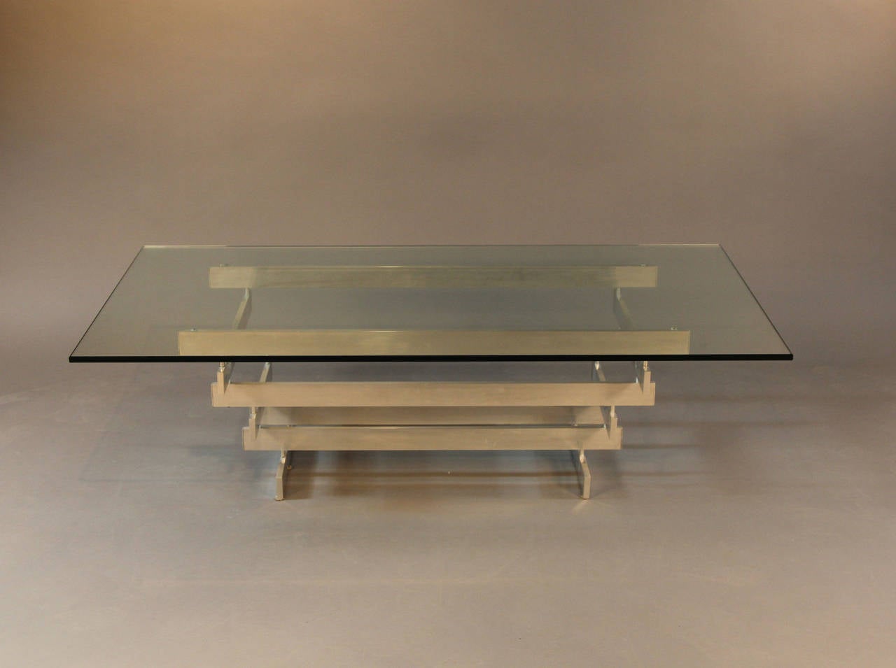 Aluminum Paul Mayen designed coffee table with glass top and multi tied base.