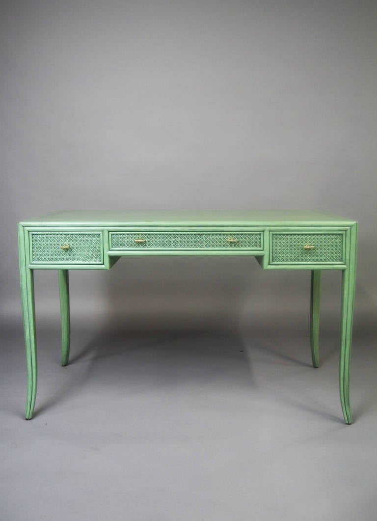 1970s McGuire writing desk with its original, beautiful, moss green, custom ordered finish. Desk has caned detail, slightly splayed legs, and faux bamboo brass pulls. It is finished on all sides and in original excellent condition.