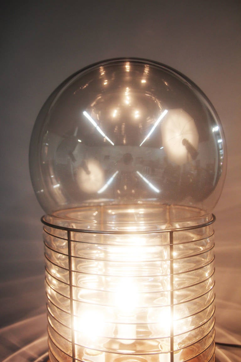 Italian designer Gae Aulenti designed this lamp for Artemide in the 1970s. This is a very rare but wonderful globe light fixture with blown glass and metal base. Three bulb configuration.