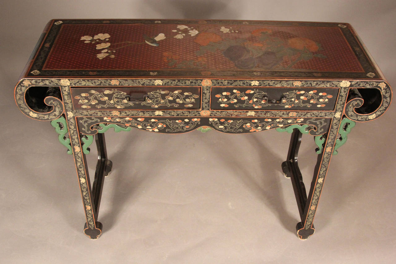 This polychrome table is completely carved and decorated with floral designs throughout the maroon top and black side panels as well as down the legs.  The incredible detailed classic Chinese designed altar table dates from the late 19th century. 