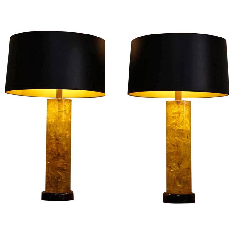 These vintage lamps are in a vibrant glowing amber tone and look fantastic with there black and gold lampshades, the black wood base and the glass finials in the same amber color. The lamps date back to the 1940s.