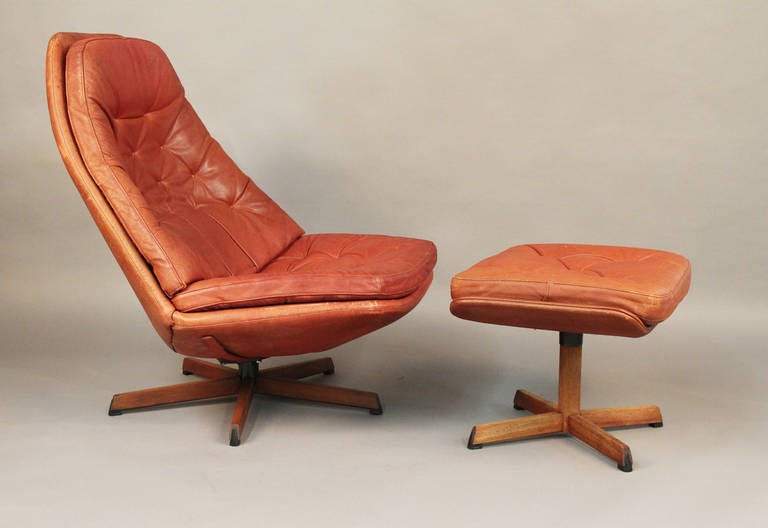 Bellissima e rara poltrona e pouf danese della metà del secolo scorso di H. H. A. Klein.  Sedia girevole e pouf.  Pelle marrone rossastra.