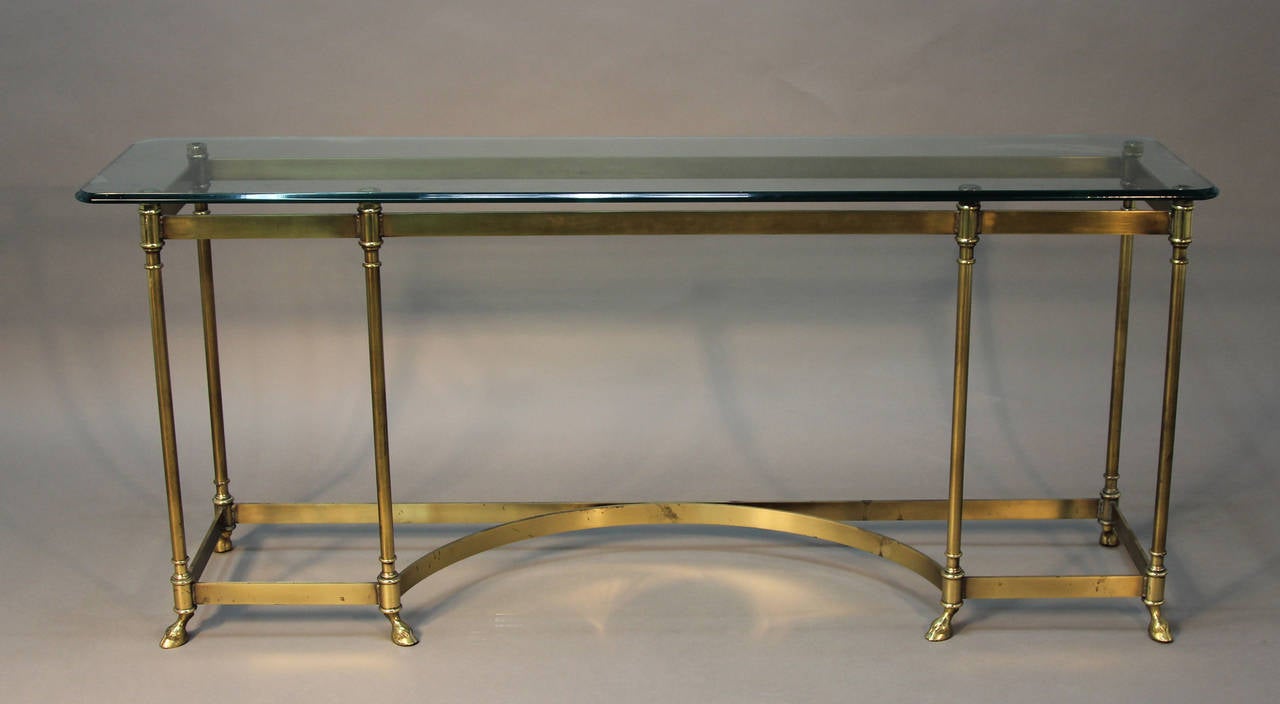 Mid-Century Modern brass console with glass top, curved detail to base and wonderfully executed hoof feet.