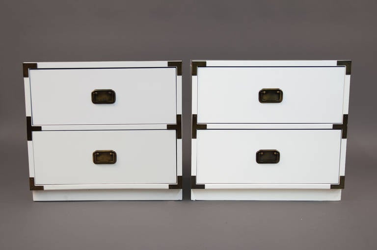 Newly white lacquered with bronze accents and hardware, two drawer nightstand or chests, or bedside tables.