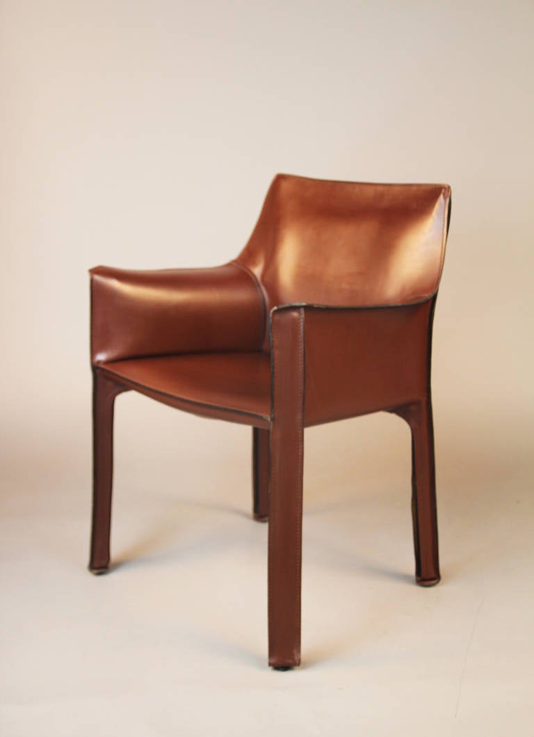 Pair of Cassina Cab 413 chairs designed by Mario Bellini.  Hand stitched saddle leather in tobacco brown, over tubular frame.