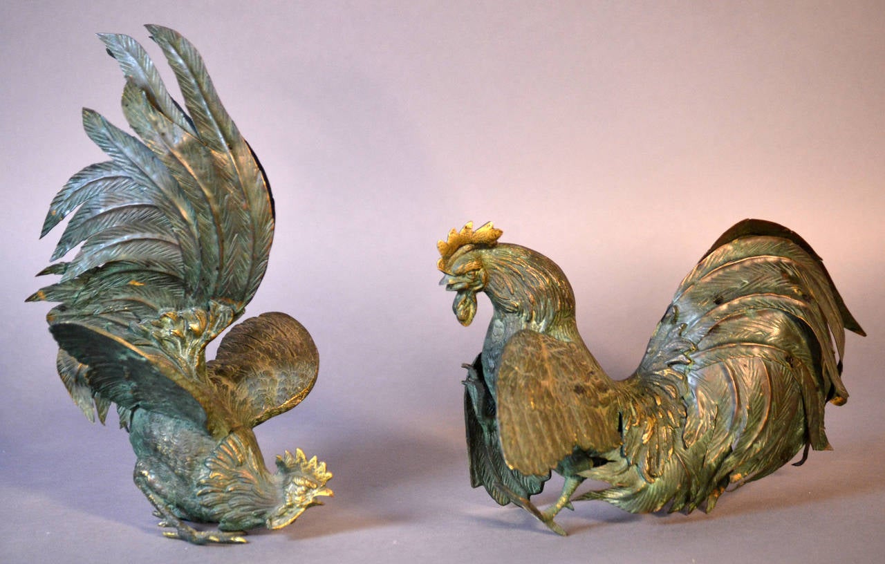 Great pair of fighting cocks sculptures. These animated bird sculptures are cast and stamped and the tail feathers are hand tooled with exquisite details, each has a great patina.