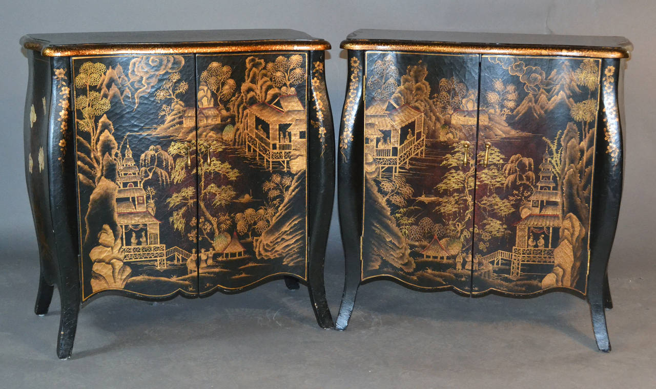 Pair of beautiful Chinese demilune cabinets featuring hand-painted detailed oriental scenes on an antiqued black lacquered background; each cabinet has one shelf inside and antiqued brass hardware.