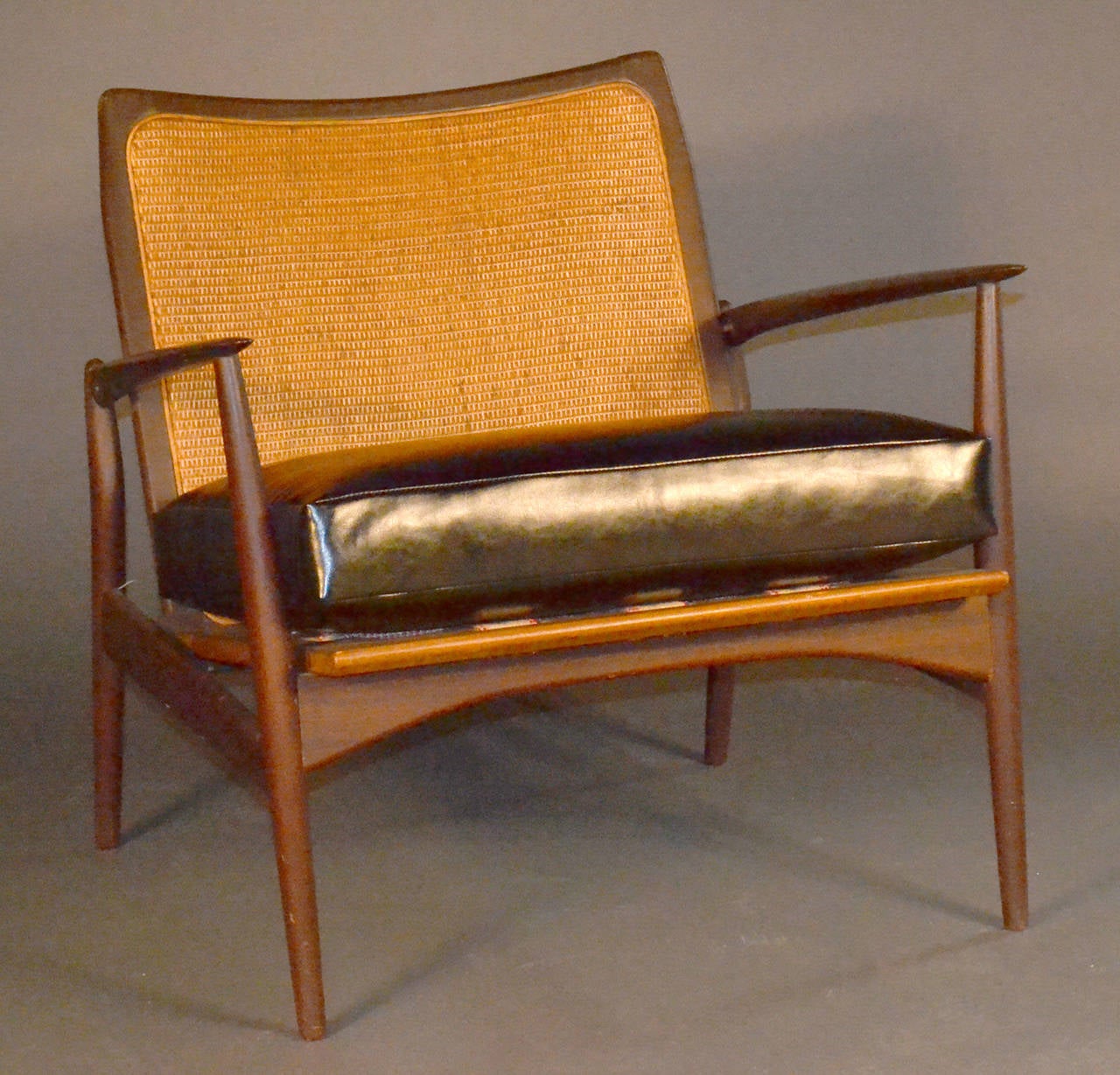 Very unique caned back teak lounge chair. Newly replaced caned back to match original. Brand new vinyl cushion and seat straps.