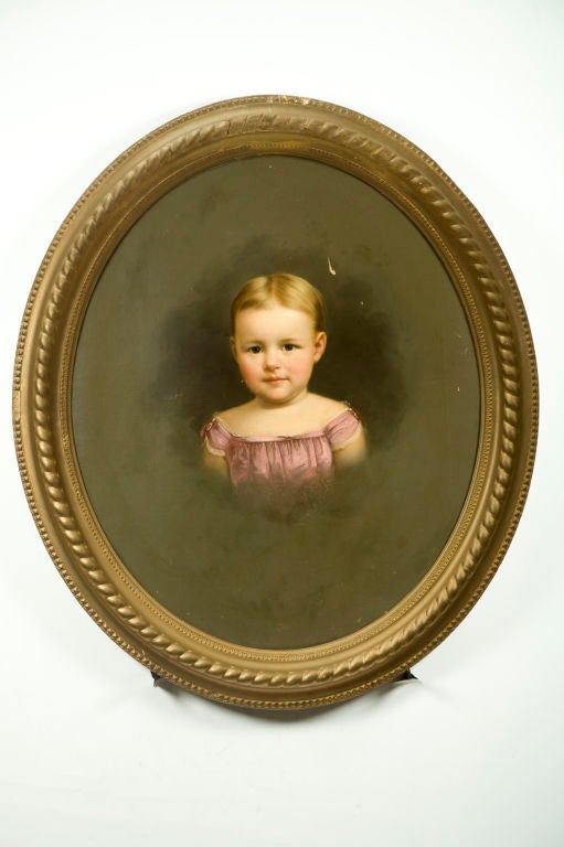 A lovely, large oval antique oil painting portrait on canvas of a young child’s head and shoulders. English or American circa 1900. Unsigned.