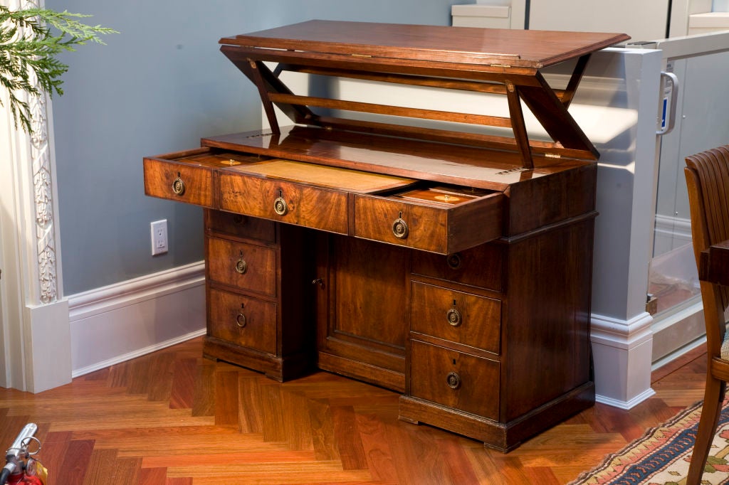 A fine and rare late 18thC English mahogany knee-hole architect's desk finished in the round; the top slants up for reading, or cantilevers up for either reading or writing while standing up; the top drawer opens to reveal a leather topped writing