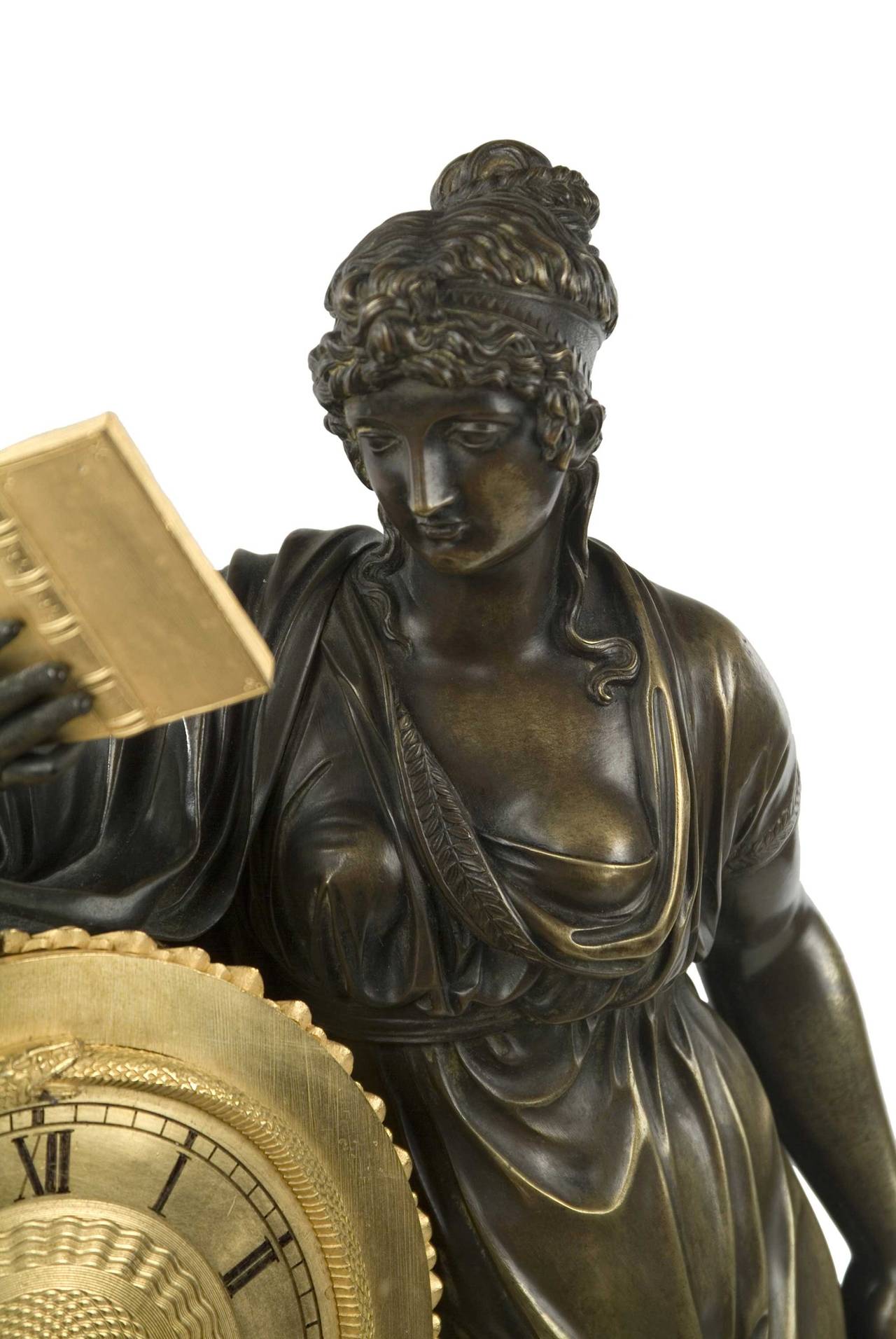 Period French Empire gilt and patinated bronze clock with a figure representing Clio, the Greek Muse of History and Writing. Clio was responsible for transmitting her wisdom of history into the minds of the human race. The main subject of the clock