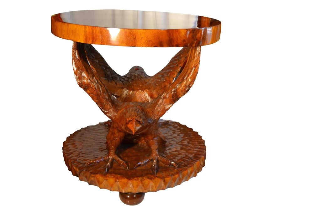 A large teak table carved with two winged eagles