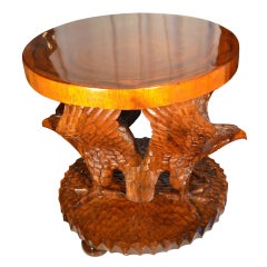A large teak table carved with two winged eagles A large teak table carved with two winged eagles