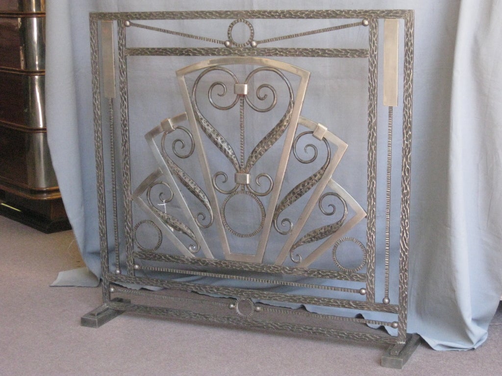 Important French Modernist firescreen attributed to Raymond Subes,unusual two tone in hand forged iron with polished nickeled accents. Chevron shaped/ fan motif with circular and scroll inner details bordered by a linear framework of superb martele