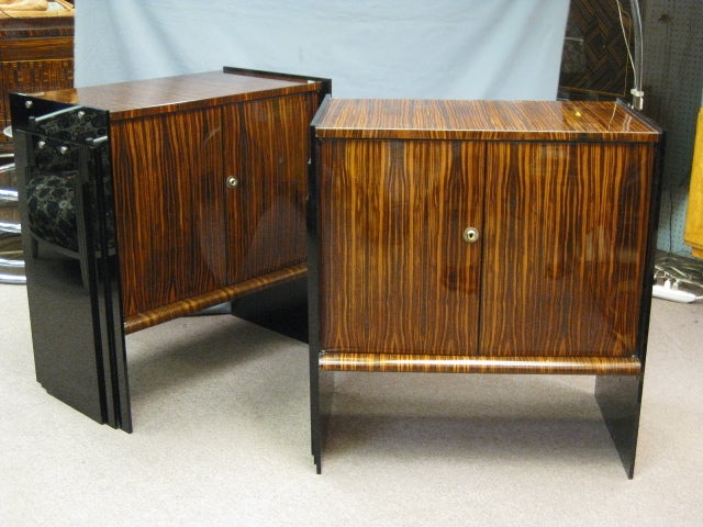 Pair of fine French Art Deco ebene de Macassar cabinets. The unusual double front bombay doors puff outward like billowy down pillows, while the stepped black plexi panels extend the full length of the side serving as both a visual and structural
