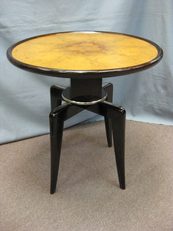 Fine French Art Deco spider table, highly sculptural in two tone in amboyna and mahogany with a dark walnut stain. The circular top surrounded by a bull nose molding and raised on a bull nose nickeled trimmed wooden cube ending in four elegant
