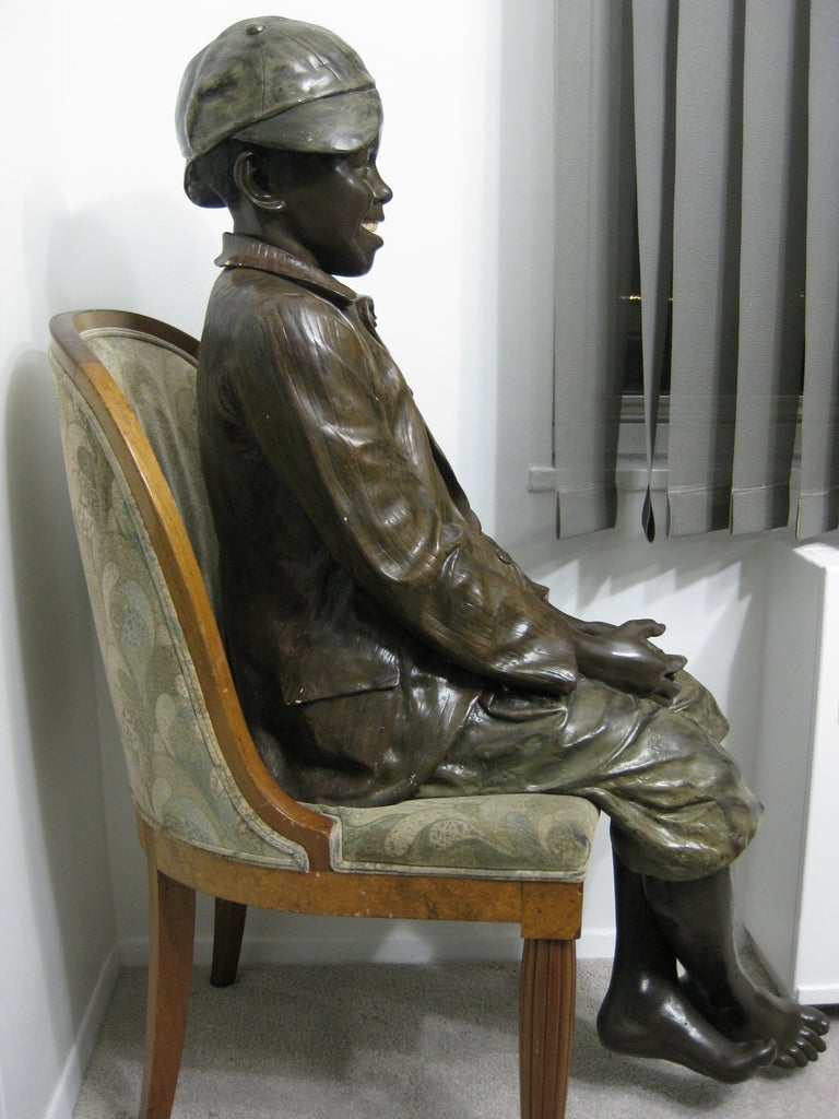 Lifesize Goldscheider polychrome figure of a black boy seated 1