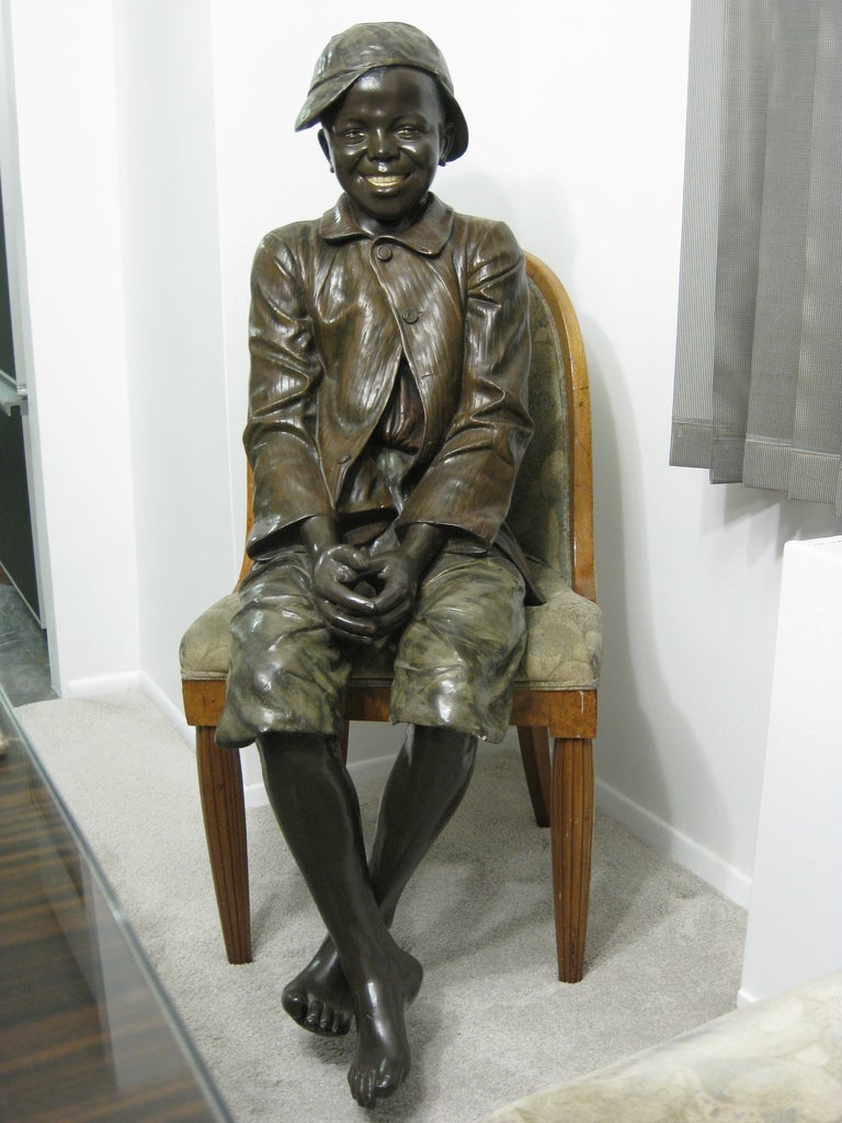 Lifesize Goldscheider polychrome figure of a black boy seated 2