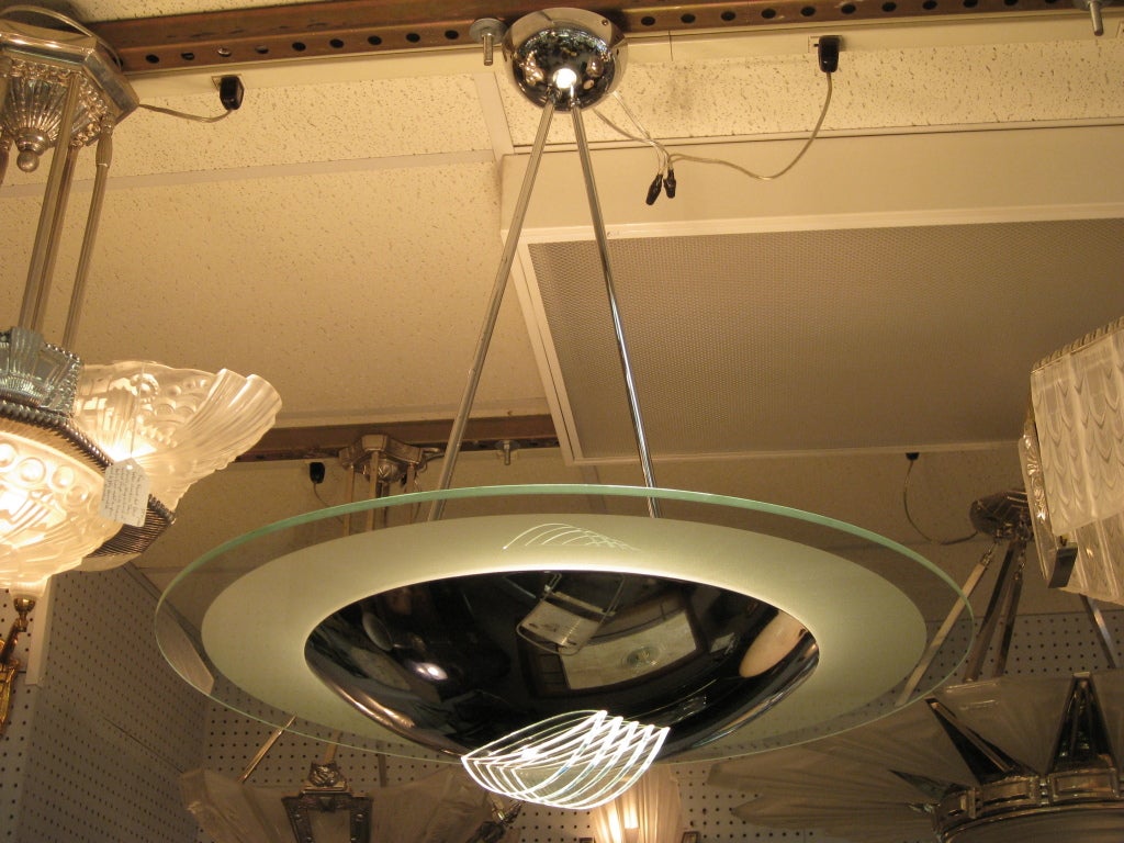 French Modernist chandelier attributed to Maison Desny. Large flat Saturn like disc in frosted glass with polished rim atop a highly polished dome ending in five clear demi-lune glass finials. The two support rods form a triangular pattern and end