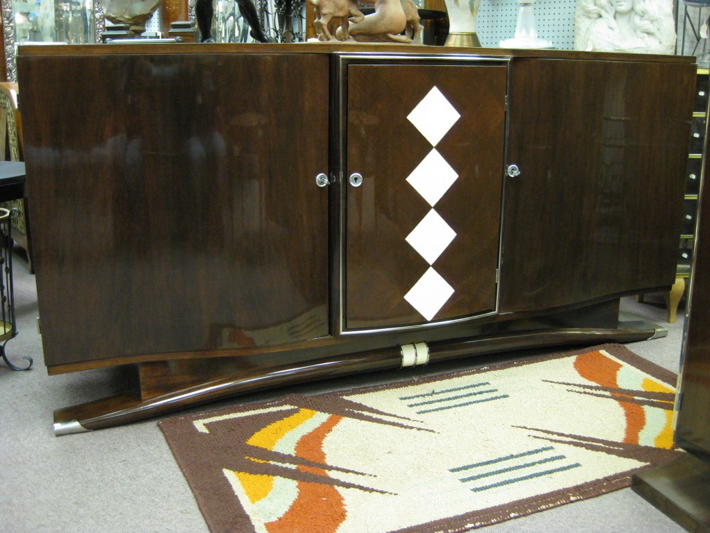 Dramatic bow front credenza attributed to Andre Frechet, with a line of diamond shapes in shagreen inlaid in a field of parquetry wood veneer. Nickel-plated bronze framing delineates the central cabinet opening from the side wings with a sleek