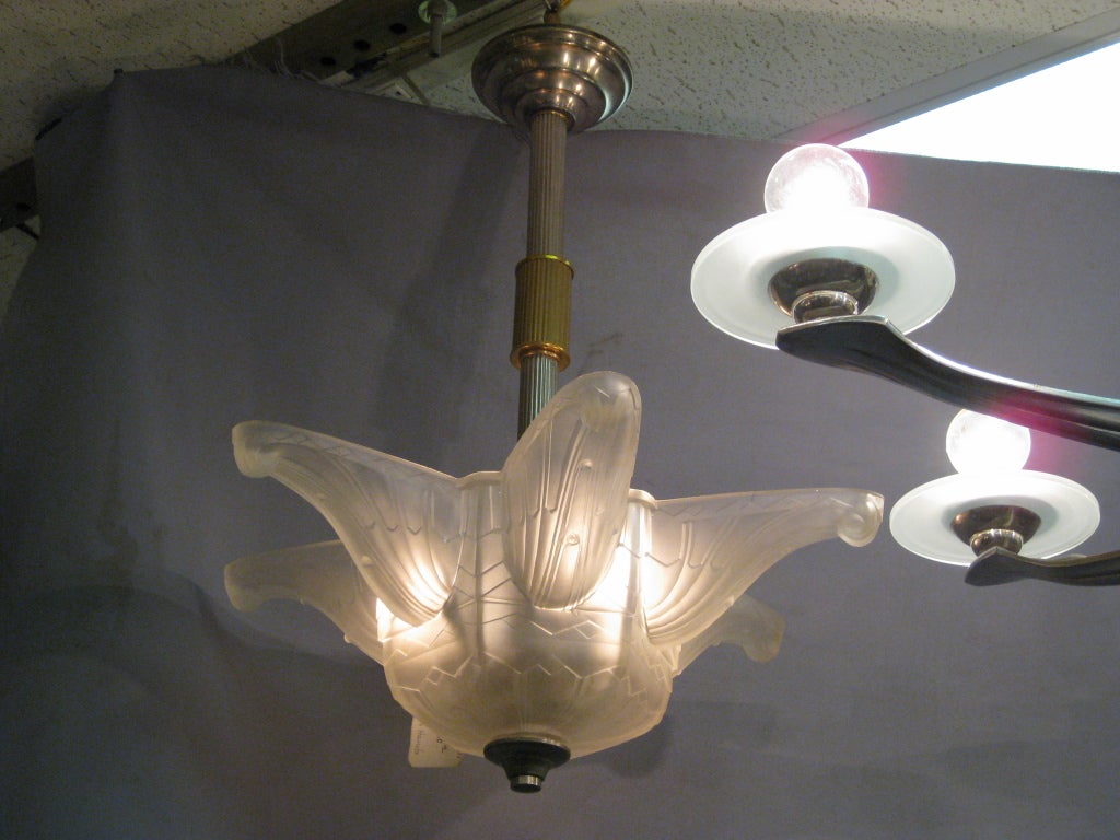 Fine French Art Deco frosted art glass chandelier attributed to Hanots. The six pointed star shape accentuated with geometric patterns creates a distinctive effect to dress up any space. The body is suspended by a single satin nickel bronze reeded