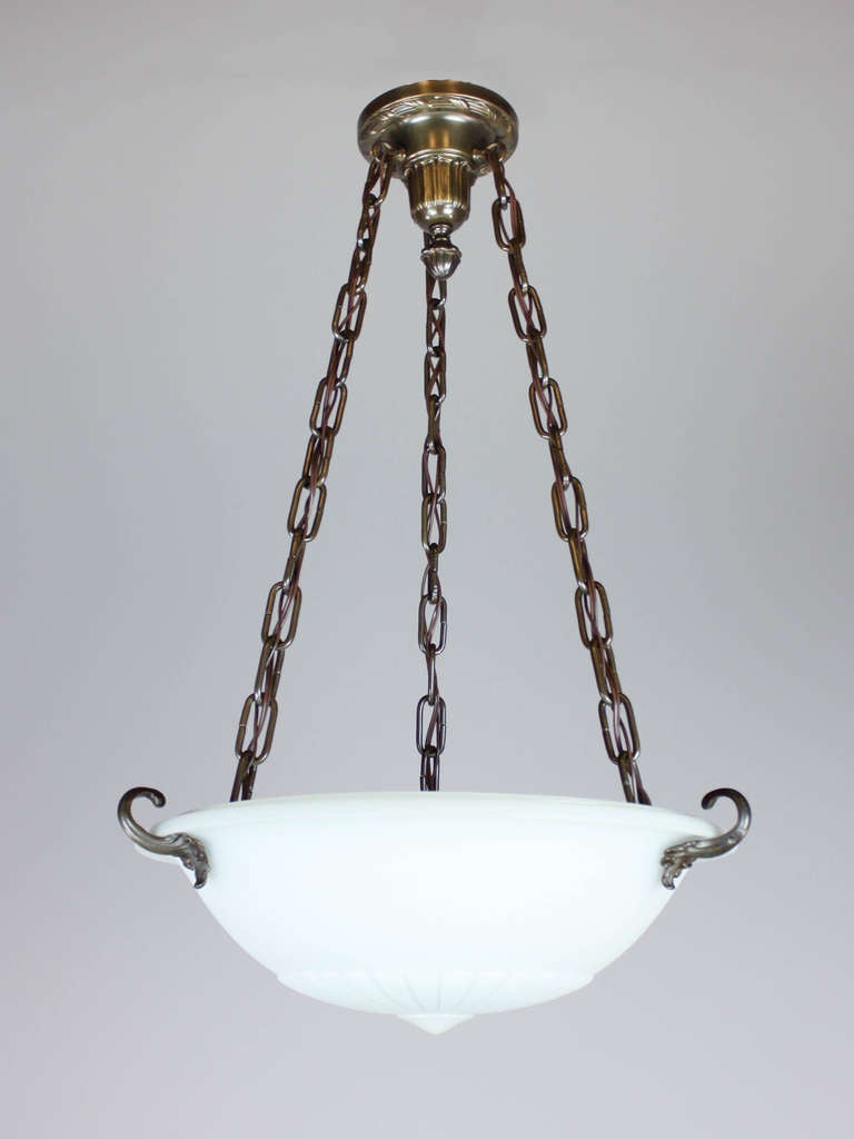 Ca. 1920 Colonial Revival style light fixture with heavy-cast Lennox glass bowl. Beautifully decorated with ribbed detail and hooked foliate hardware. Interior has 3 sockets, re-wired and ready to mount.
Measurements: 31