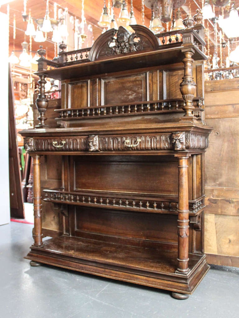 Ca. 1880 Unusual carved walnut hutch with figural faces and decorative surface work. Original hardware and finish, 2 drawers and multiple layered shelving. Measurements: 70