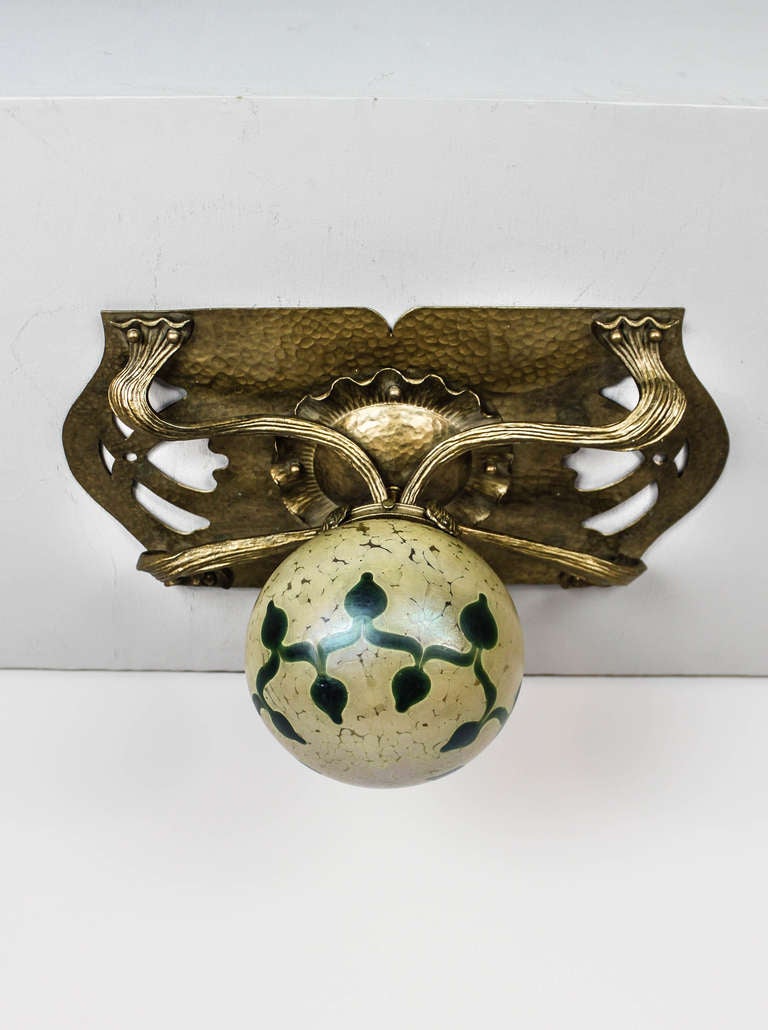 Ca. 1905 A hammered brass flush mount, highly organic piece in the Art Nouveau style, this brass fixture retains it's original finish and fittings. Super high-quality art glass globe shade in the style of Loetz.
Measurements: 18