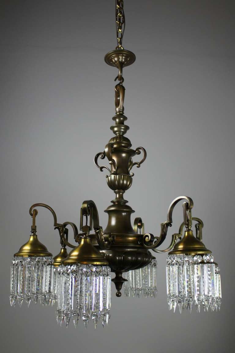 Removed from a historic Vancouver Ballroom, circa 1915. Heavy cast bronze fixture with elongated 'S' churned arms with decorated florets finished with notched crystals. A masculine, yet elegant fixture.
Measurements: 44″ L x 35″ diameter.