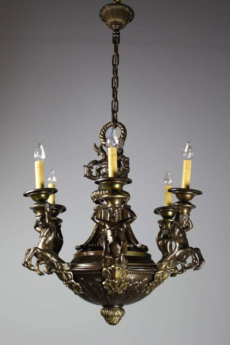 A fabulous Italian Renaissance Revival figural light, depicting 6 beautifully cast centaurs holding candles on a hearty acanthus leaf decorated body. Heavy cast in a rich chocolate bronze, this light makes a character filled addition to any space.