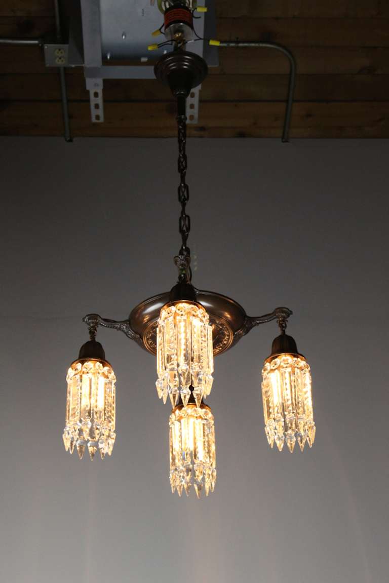 Circa 1925 Pan fixture made by Lightollier's "After Sunset" collection.

A darling light fitted with notched crystal and Sheffield-style hooked arms in a deep bronze finish. Re-wired and ready to hang.
Measurements: 40"H x 20″Dia