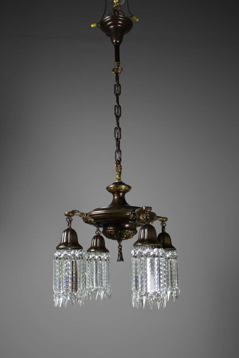 Circa 1925 Pan fixture made by Lightolier, as part of their “After Sunset” collection. A very pretty four arm light fitted with notched crystal and Sheffield-style hooked arms in a deep bronze finish. A perfect choice if you are looking to dignify