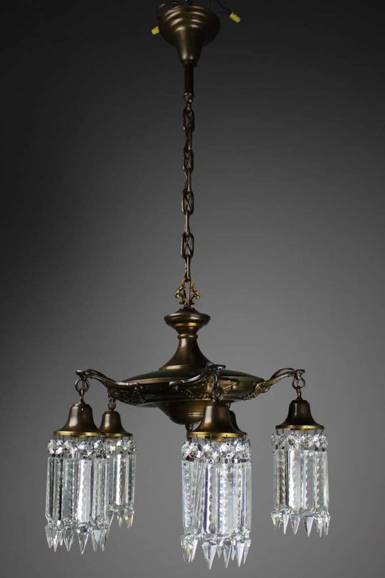 Circa 1920 This lovely crystal chandelier was sourced in Cincinnati, Ohio. Its chocolate bronze finish was brought back to life and the fixture itself has been restored, rewired and is ready to hang.  Fitted with notched crystal.
Measurements:
