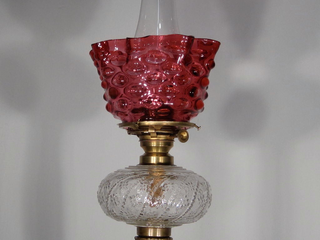 Top quality original finish piano lamp cast in the shape of a bird's leg, circa 1880. Fitted with a period cranberry hobnail shade.
Measurements: 43