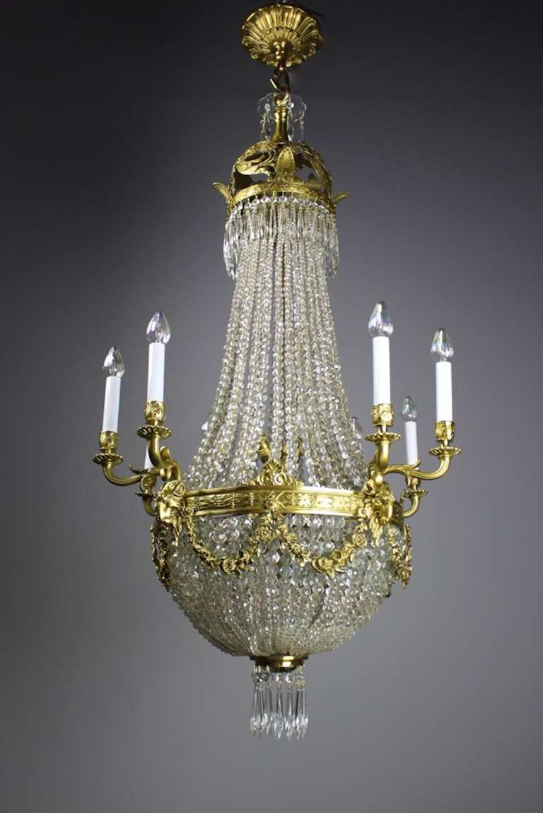 This Edwardian cut-crystal chandelier is of the highest quality. Taking a beautiful basket shape, this crystal chandelier uses Baccarat crystal beads. Along with interior bulbs that emanate a peach-toned glow, the outside of the basket has four lit