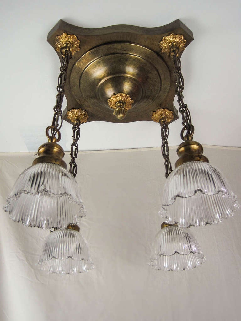 Ca. 1912 Decorated 4-light Edwardian/Gothic flush mount fixture decorated with profusely cast gilt embellishments. Fitted with re-cast holophane shades. Measurements: 19.5