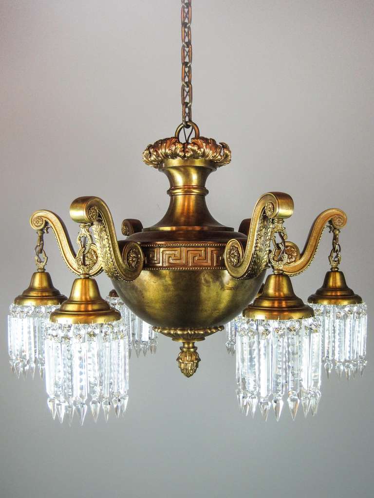 Ca. 1906 Monumental Beaux-Arts six-arm brass light fixture with the highest quality castings. A band of greek-key ribbon surrounds the circular body containing six bent arms decorated with rosettes and stylized flourishes. The upper section is