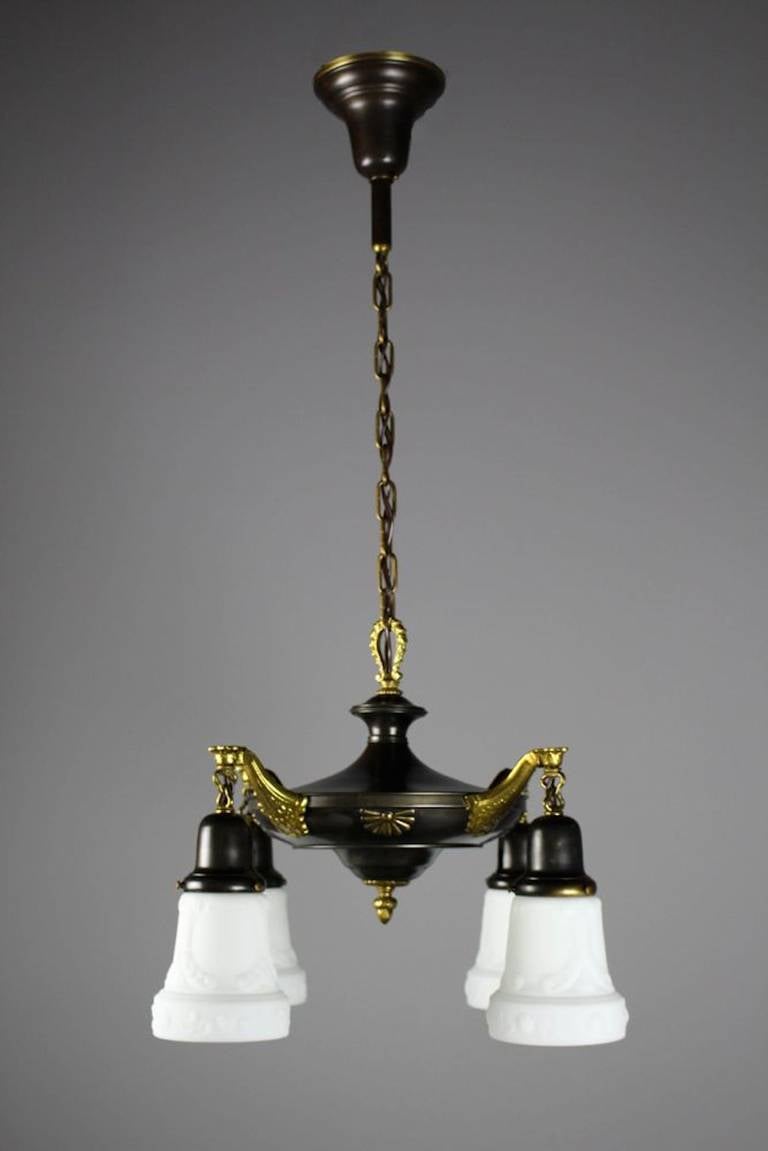 Circa 1925. Note the beautiful pressed patterns between the arms of this Colonial Revival fixture. Brought back to its original antique brass finish. Cleaned, rewired, restored, ready to hang. 
Measurements: 34"H X 20"W SKU: DF1184