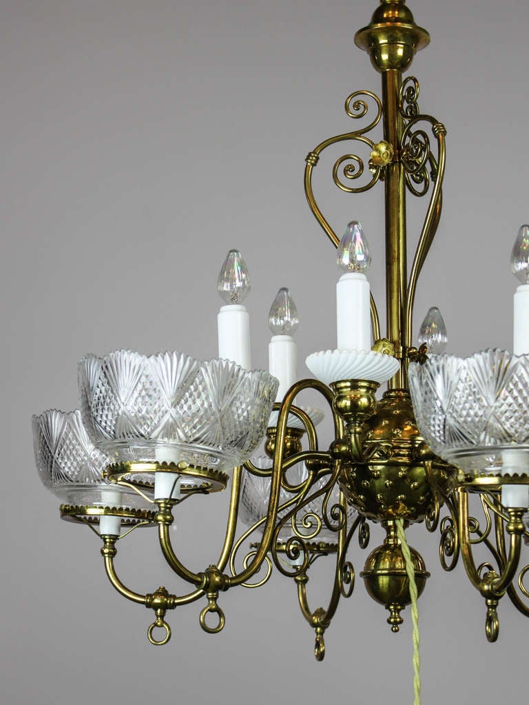 Ca. 1885 Victorian gas fixture converted to electric and restored in gold.
This fixture was electrified circa 1915 with the addition of six milk glass ‘candles’ and a hanging toggle switch (switch is now non-functioning).
Of note is the whimsical