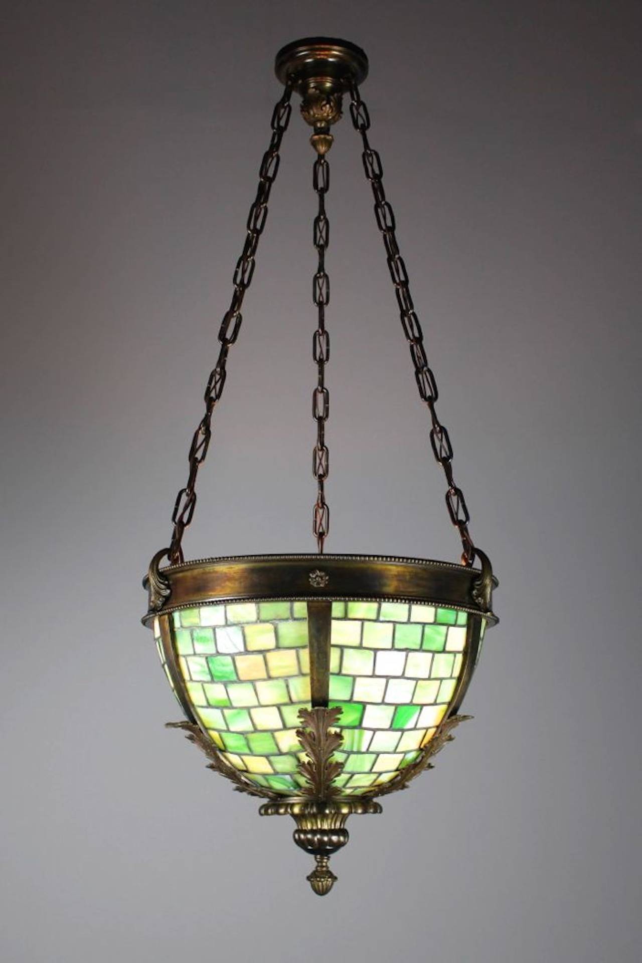 Ca. 1915. This is an exceptionally cast brass bowl fixture, fitted with green slag glass leaded panels, featuring decorative foliate castings. This light is truly lovely to look upon, and made with quality craftsmanship. Retaining an interesting,